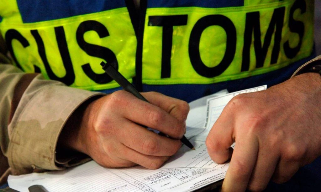 Agente de aduanas verificando los contenidos del contenedor enviado a Estados Unidos